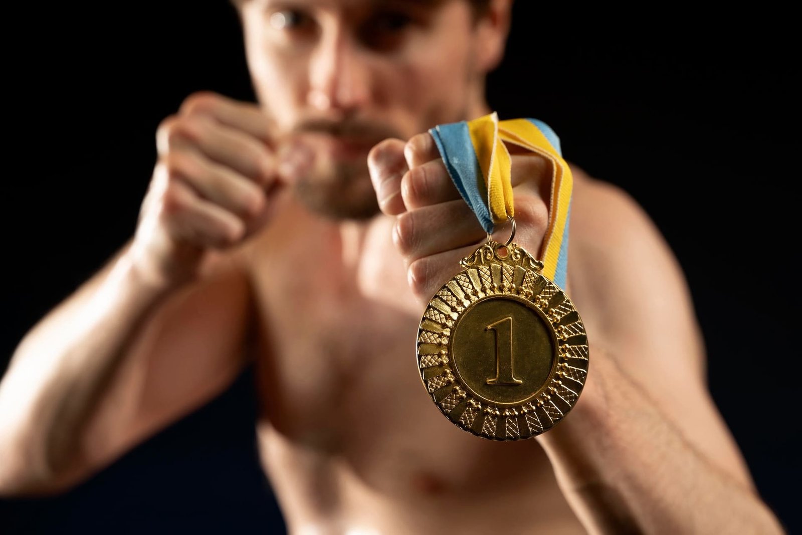 boxeador con medalla de oro en mano mirando profundamente a los ojos representa el valor de ser el primero y el esfuerzo detras de dus guates asemeja el valor de ser la agencia SEO en Guatemala 1 el mejor ONE .jpg