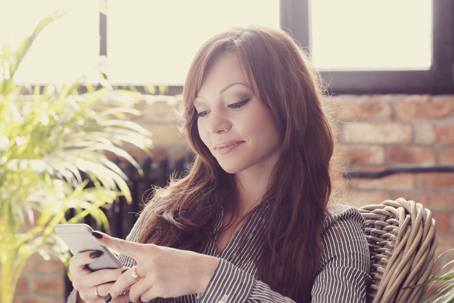 SEO SEM Guatemala - Mujer profesional revisando su smartphone, simbolizando estrategias de marketing digital.